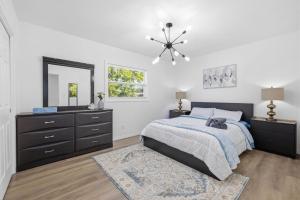 a bedroom with a bed and a dresser and a mirror at Clearwater Paradise w Hot Tub-Backyard Bliss Near Beach & Hot Spots in Clearwater