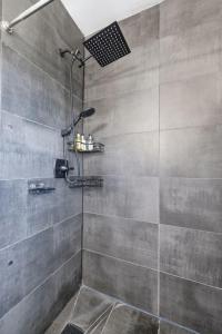 a shower with a shower head in a bathroom at Clearwater Paradise w Hot Tub-Backyard Bliss Near Beach & Hot Spots in Clearwater +54 photos