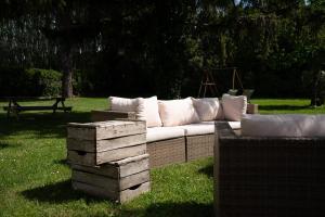 a white couch sitting in the grass in a park at Logement charme provençal in Cabannes