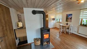a wood stove in a living room with a table at Ferienwohnung Dorfleben in Weiler-Simmerberg