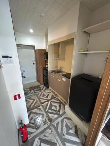 a small kitchen with a refrigerator and a sink at 東尋坊近く自転車無料 コンビニ目の前1ルーム貸切 in Mikuni +14 photos