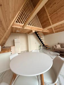 a white table and chairs in a room with wooden ceilings at Hyde Retreat in Holda +12 photos