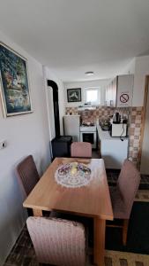 a kitchen with a wooden table and chairs in a room at Kod mosta in Pirot