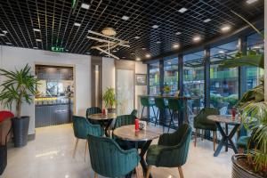 a restaurant with tables and chairs and windows at Wyn Residence Batumi in Batumi