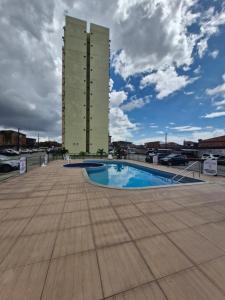 a building with a swimming pool in front of a building at Apartamento Confortável in Ananindeua