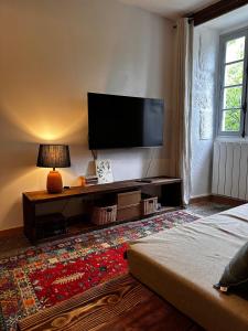 a living room with a flat screen tv on the wall at Mas Ardéchois de caractère in Labeaume