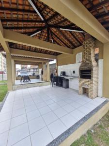 an outdoor patio with a fireplace and an outdoor kitchen at Apartamento Confortável in Ananindeua