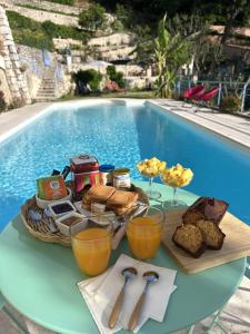 a tray of food on a table next to a pool at Des Ciappes et des Fées in Menton