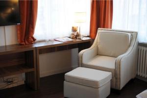ルツェルンにあるファルケン アム ロートジーのデスク、椅子、テディベアが備わる客室です。