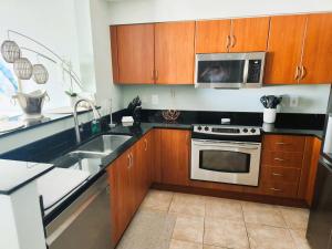 a kitchen with a sink and a microwave at Turnkey Tranquility with Marina & Intercoastal views in Lantana +30 photos