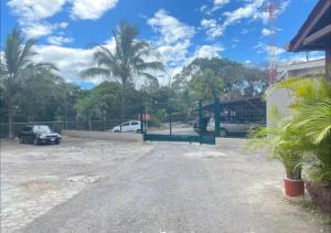a parking lot with parked cars and palm trees at Apartamento H González #12 in Alajuela