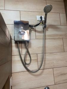 a shower with a hose attached to the wall at Apartamento H González #12 in Alajuela