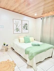 a bedroom with a bed with a green blanket on it at Apartamento H González #12 in Alajuela