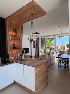 an open kitchen and living room with a table at Villa Central Palms in Palasë