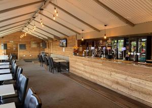 a restaurant with tables and chairs and a bar at Merryfield and Sandfields in Chapel Saint Leonards