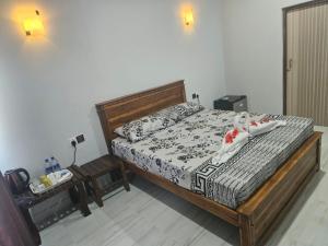 a bedroom with a large bed with a wooden frame at Tropical Inn Hotel in Kankesanturai