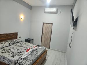 a bedroom with a bed and a television in it at Tropical Inn Hotel in Kankesanturai