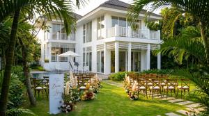 an outdoor wedding ceremony in front of a white house at Luxury Private Pool Villas at Village Danang Resort in Danang