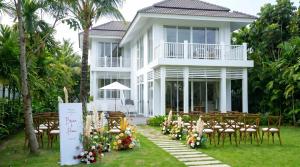 an outdoor wedding ceremony in front of a white house at Luxury Private Pool Villas at Village Danang Resort in Danang