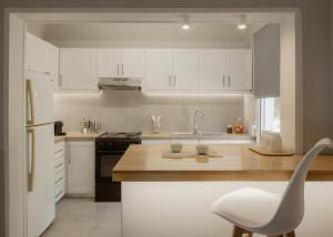 a kitchen with white cabinets and a white chair in it at Mediterranean Haven in Paleokastritsa +4 photos
