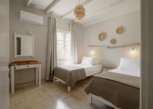 a bedroom with two beds and a desk and a window at Mediterranean Haven in Paleokastritsa