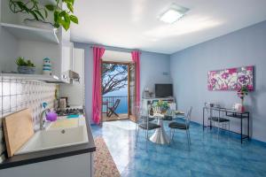 a kitchen and living room with a table and chairs at Calipso Residence in Furore