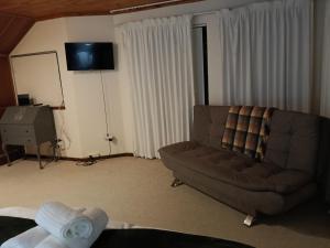 a living room with a couch and a television at The Victorian Villa in Chintsa