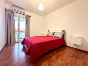 a bedroom with a bed with a red blanket at Teleferico Center Funchal in Funchal +3 photos