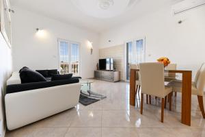 a living room with a couch and a table at Costa apartment with private pool in Preko