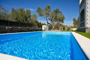 a swimming pool with blue water at Costa apartment with private pool in Preko