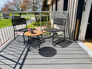 two chairs and a table on a balcony at Ferienwohnung 'kommodig' nahe der Eider in Delve