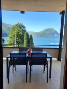 a dining room table with a view of the water at La Rosa di Ilde in Porlezza