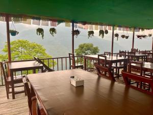 a restaurant with tables and chairs and a view of the water at Kimche Guest House in Astam