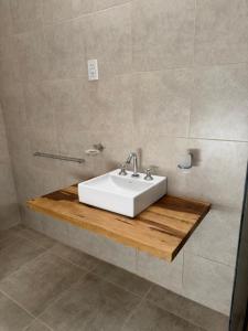 a bathroom with a white sink on a wooden counter at Sol de Alvear in General Alvear +6 photos