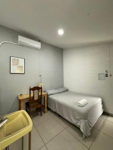 a room with two beds and a desk and a sink at Hostal El Amate #1 in Suchitoto