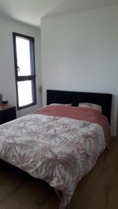 a bedroom with a bed with a comforter and a window at Le Mans Changé GP 24H DU MANS in Changé