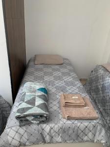 a bed with two towels and a pillow on it at Hotel Airton in Ivaiporã
