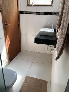 a small bathroom with a toilet and a sink at Hotel Airton in Ivaiporã