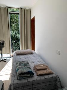 a bedroom with a bed with towels on it at Hotel Airton in Ivaiporã