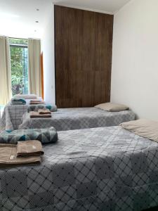 three beds in a room with towels on them at Hotel Airton in Ivaiporã