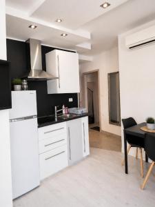 a kitchen with white cabinets and a table in a room at Apartma Sparkle in Koper +16 photos