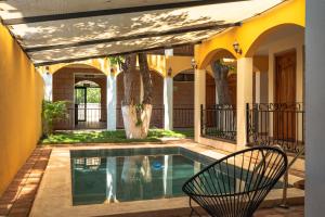 ein Swimmingpool in einem Garten mit einem gelben Haus in der Unterkunft Hotel Jabal Inn in Tixmucuy