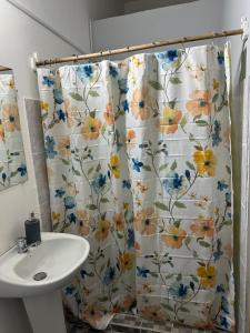 a bathroom with a shower curtain with a sink at Hostal El Amate #2 in Suchitoto