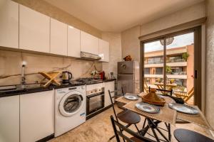 a kitchen with a table and a stove and a dishwasher at Prime location Moroccan-Style Luxury Apartment with Parking near Carré Eden Shopping Center in Marrakesh