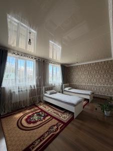 a bedroom with two beds and a rug at Hidden Valley Guesthouse in Toguz-Bulak +52 photos