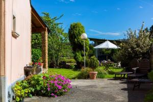 a garden with a table and chairs and flowers at Casa BRAIS in Barreiros +74 photos
