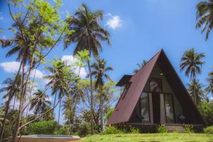 a small house on a hill with palm trees at Hideout Boomeru in Matale