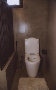 a bathroom with a white toilet in a room at Hideout Boomeru in Matale