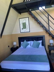 a bedroom with a large bed with blue pillows at Hideout Boomeru in Matale