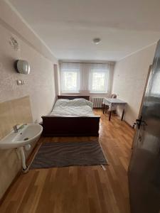 a bedroom with a bed and a sink and a bathroom at Оазис in Lutsk